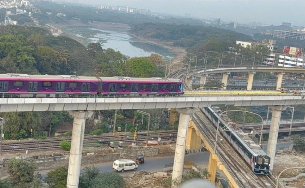 Puneri Metro Line 3 train passing directly above a Line 2 train