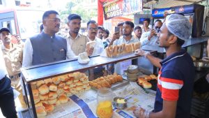 Maharashtra Transport Minister Pratap Sarnaik inspecting food items and facilities at a bus depot eatery, surrounded by staff and officials.