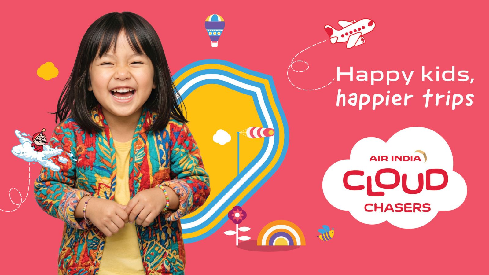 A young girl with dark hair and a colorful patterned jacket laughs joyfully against a vibrant pink background. To her right, the Air India Cloud Chasers logo is displayed inside a white cloud graphic, accompanied by the slogan "Happy kids, happier trips." The playful design includes whimsical illustrations of a cartoon airplane, a hot air balloon, a rainbow, and a reimagined, youthful version of the iconic Maharaja mascot flying on a small cloud.