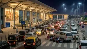 A scene outside Pune Airport with a lot of vehicles in a chaotic fashion creating a congestion. These vehicles are waiting to pick up the arriving passengers.