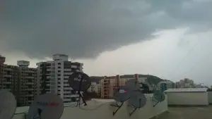 A wide image of a terrace of a building in Pune with dark rain clouds forming in the background.