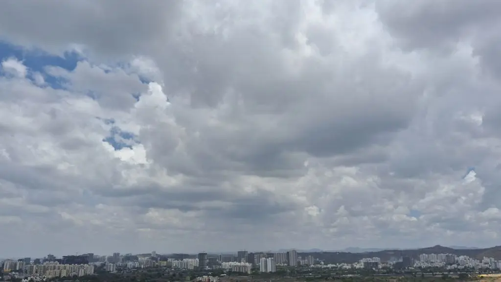 A wide-angle image of Pune sky showing the city skyline and scattered clouds in the sky right up to where eye can see, showing dry conditions in the city in the absence of monsoon rain.